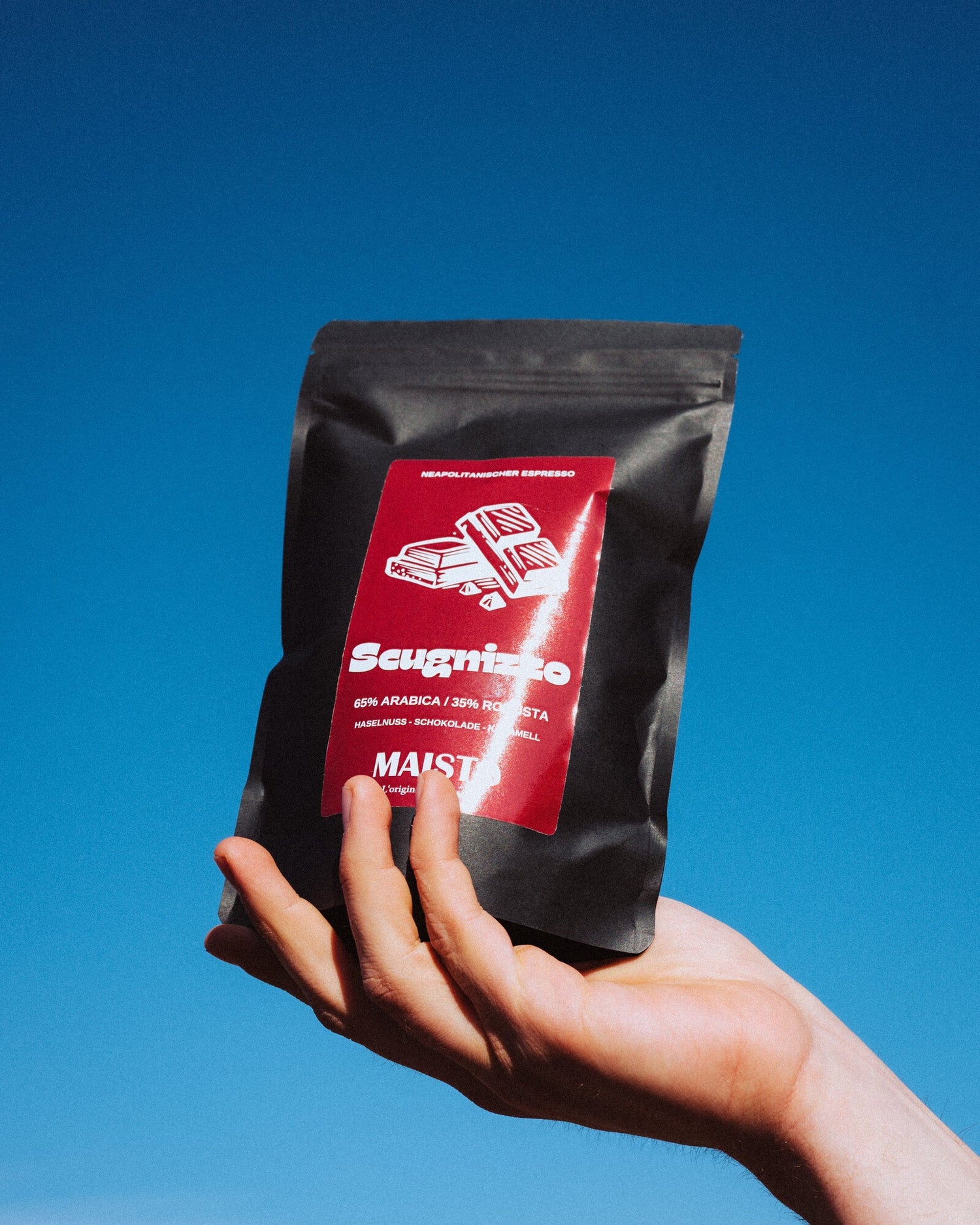 Kaffeetüte von Maisto Caffé in der Hand