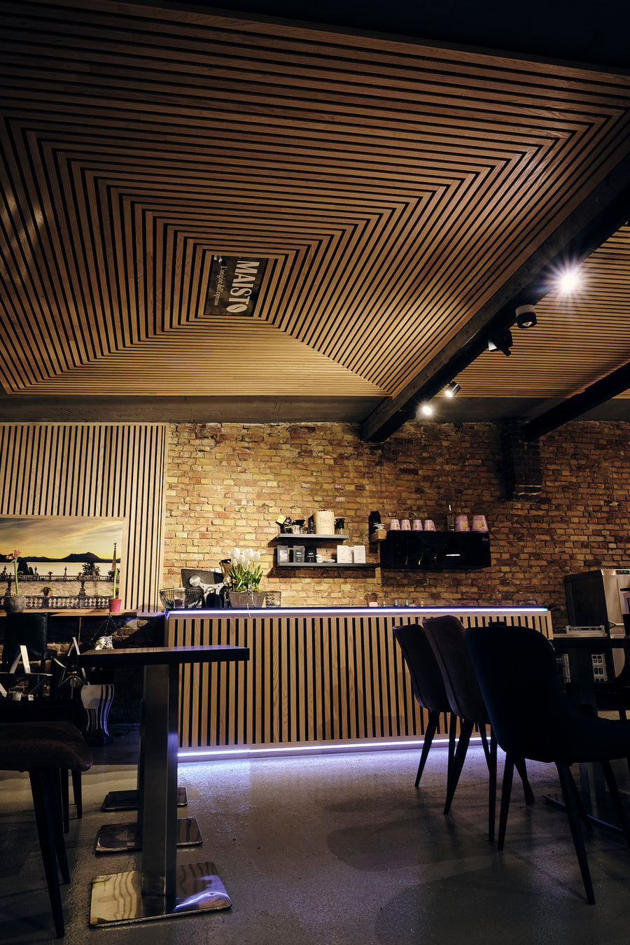 Gastraum mit Holzlamellen-Decke und Pendelleuchten im Maisto Caffè