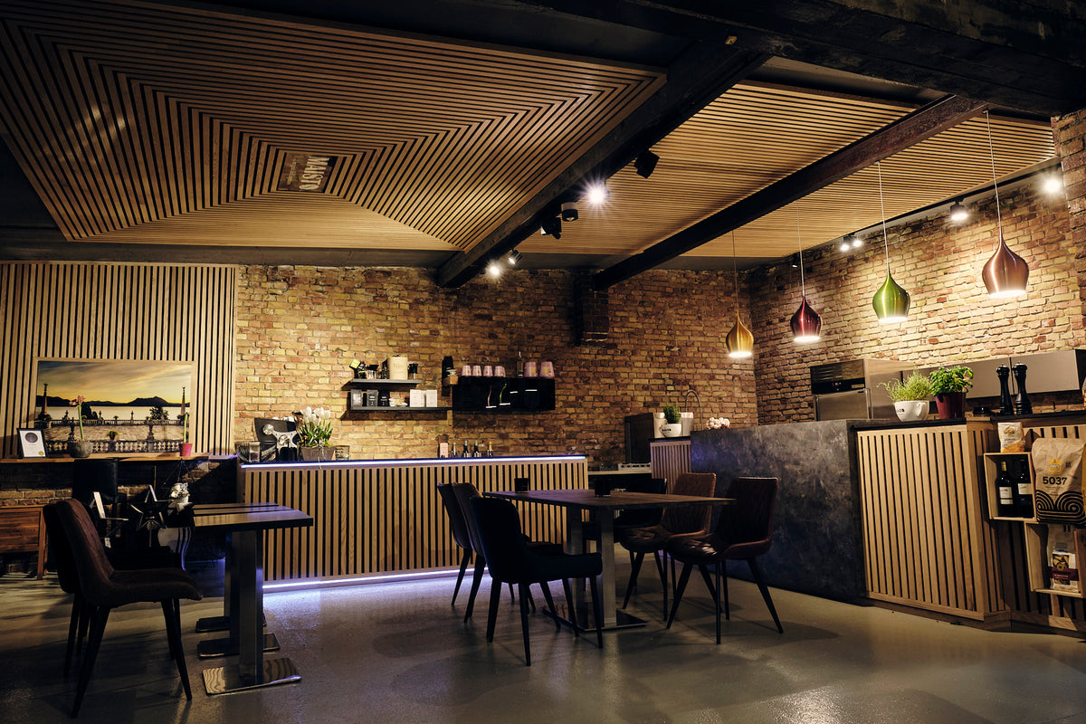 Gastraum des Maisto Caffè mit Holztischen und Backsteinwand
